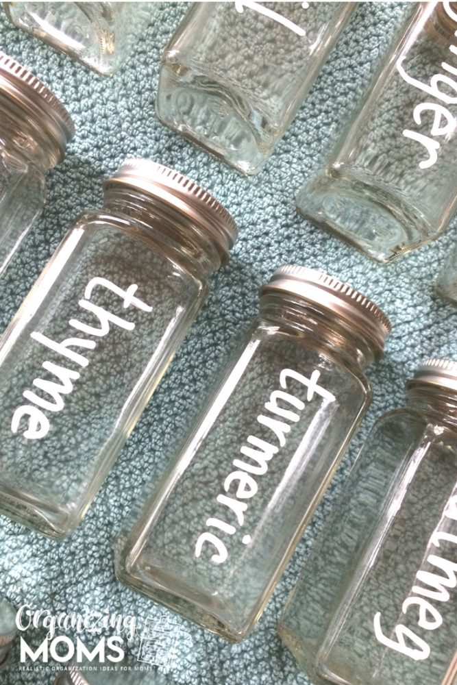 A close up spice bottles labeled with white chalk marker on blue background