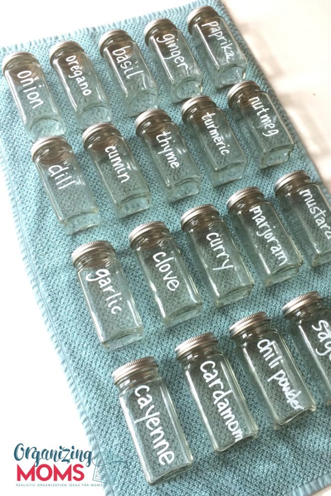 A close up spice bottles labeled with white chalk marker on blue background