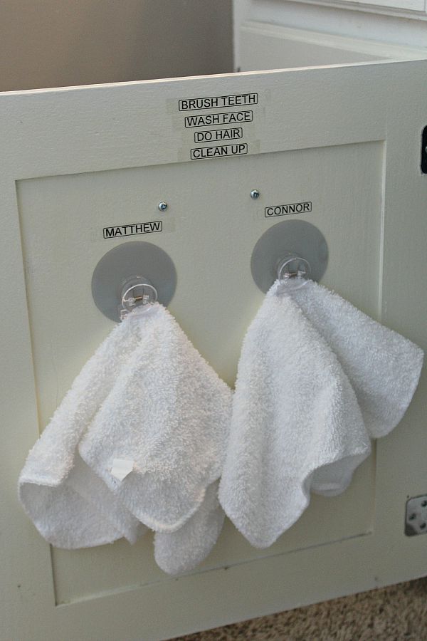 Organized-Morning-Routine- shows inside of bathroom cabinet with clips for washcloths and steps fo morning routine displayed on cabinet surface