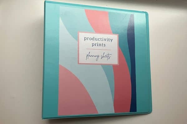 Productivity prints plan sheet on white table in blue binder