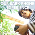 Image of boy looking at cell phone and smiling. Text says Our Bark Phone Experience.