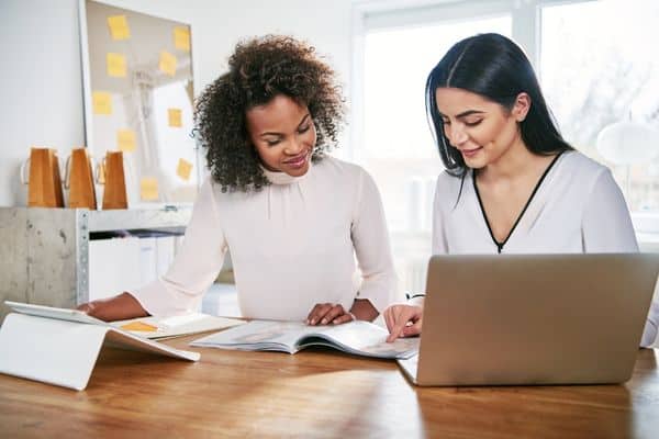 two woman working alongside each other using body doubling to be productive