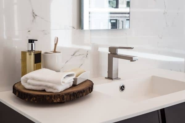 sink with folded towel, soap, toothbrush to symbolize bathroom organization