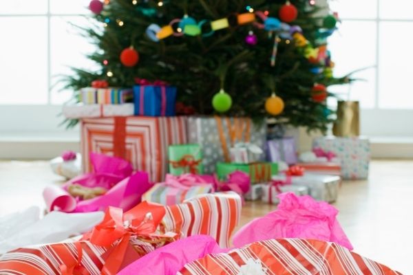 crumpled wrapping paper and christmas clutter in front of christmas tree