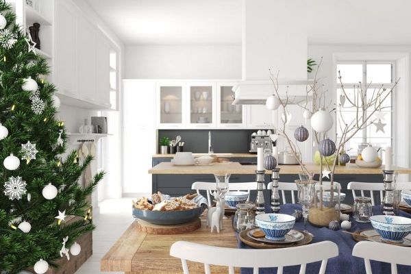 A dining room decorated for Christmas filled with furniture and vase on a table