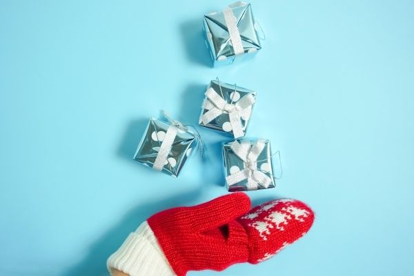 red mitten with small clutter free gifts on blue background