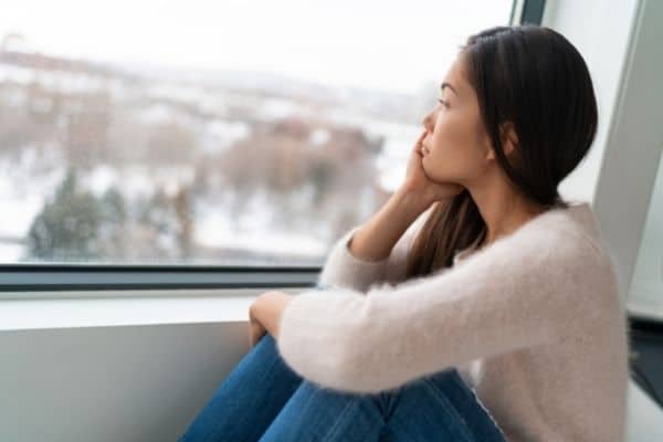 woman staring out window daydreaming