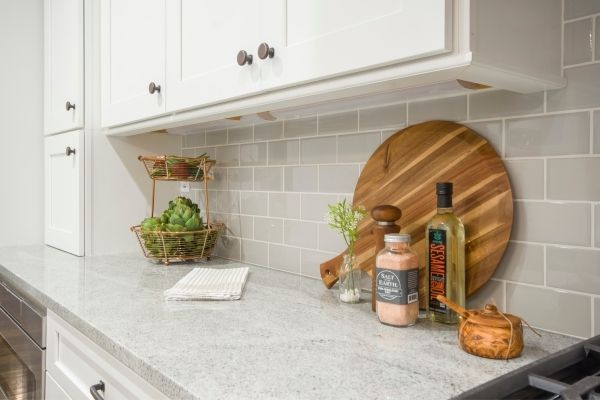 A kitchen countertop with fruit, towel, cutting board