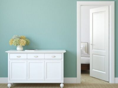 decluttered and organized white dresser and door with blue wall