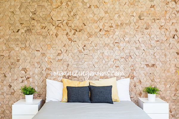 A large bed sitting next to a wooden wall in decluttered bedroom