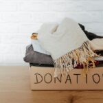 donation boxed filled with items collected because of decluttering habit on wooden floor