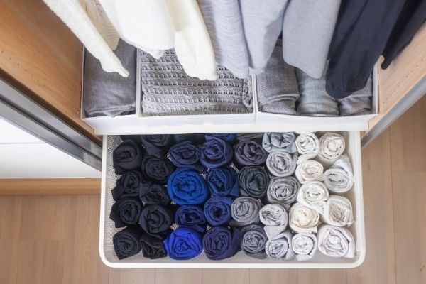 decluttering motivation image of clutter free closet drawer with neatly rolled clothes