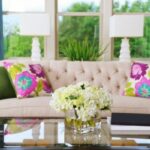 decluttered table with hydrangeas sofa with colorful pillows in front of window