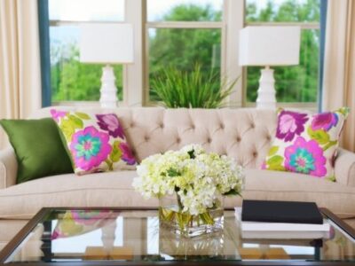 decluttered table with hydrangeas sofa with colorful pillows in front of window