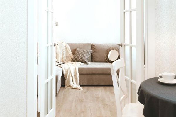 A brown sofa behind white french doors