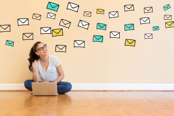 woman working on computer with drawings of envelopes above her
