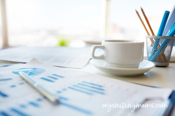 Coffee mug and plan papers on a desk.