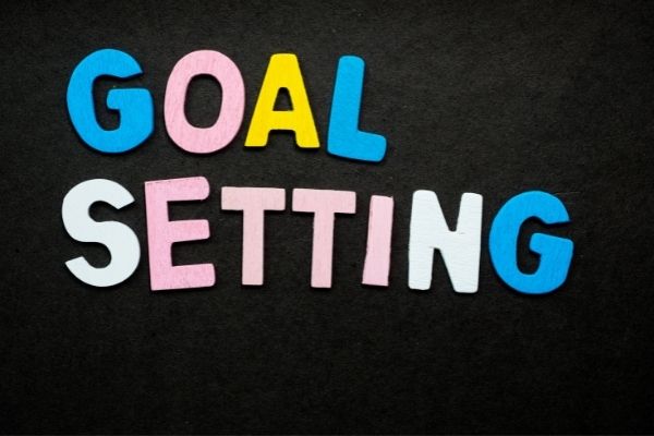 colorful letters spell out goal setting on black background