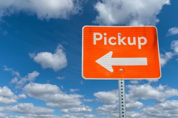 A pickup sign in front of a cloudy blue sky