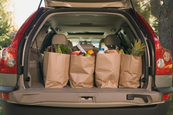 An open trunk of a car with groceries bags inside