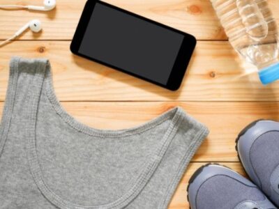 exercise clothes shoes and cell phone on wooden floor