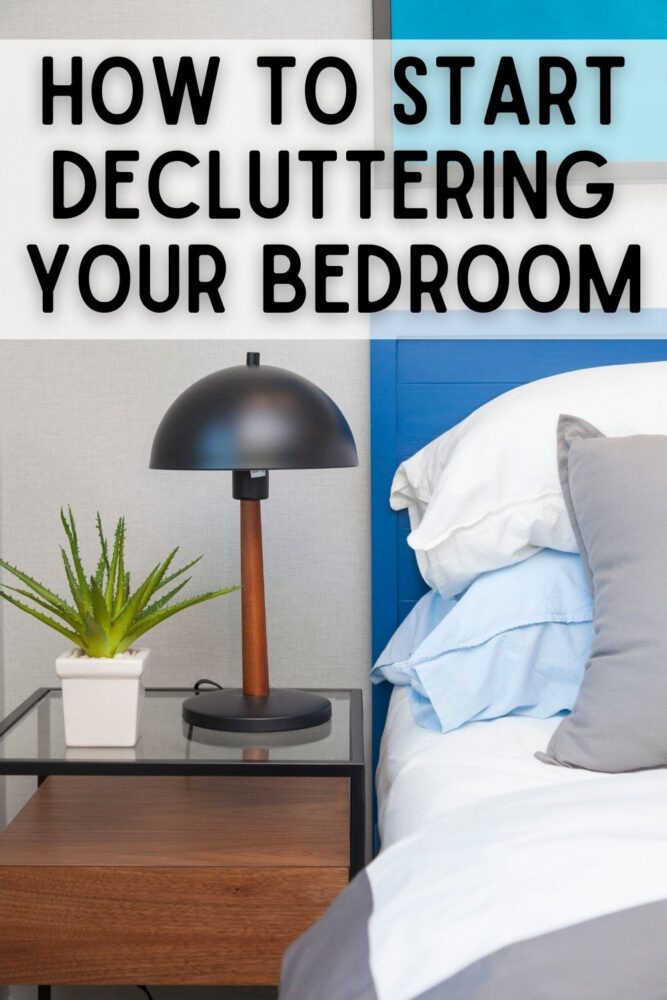 text: how to start decluttering your bedroom image: nightstand with lamp, plant, made bed with blue headboard