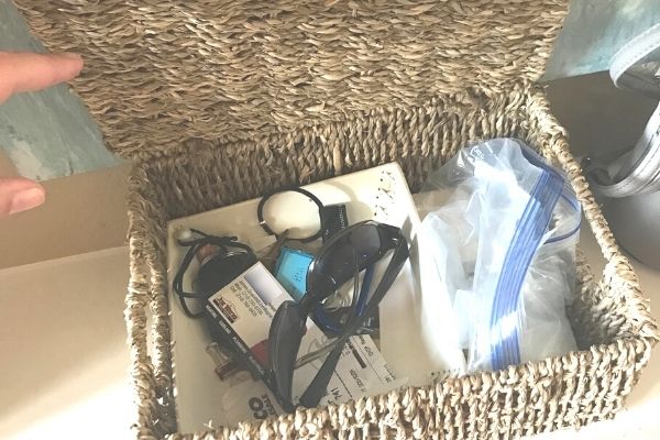 open basket with sunglasses, plastic baggie, change, receipts inside