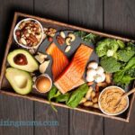 A box filled with different healthy keto diet foods on a wooden table