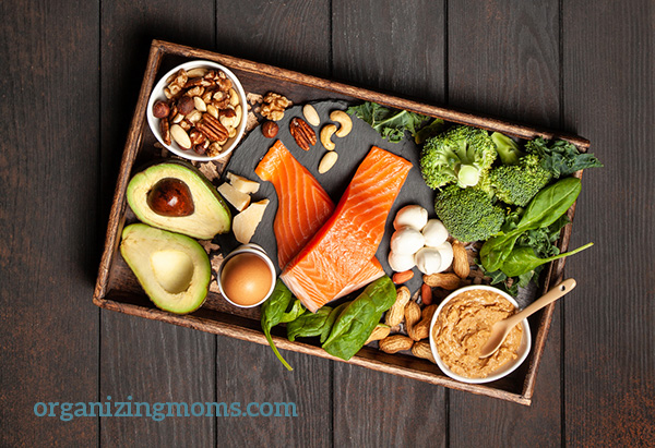 A box filled with different healthy keto diet foods on a wooden table