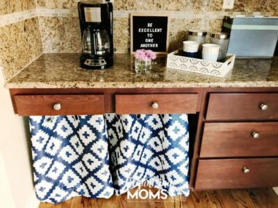 Create more storage space in your kitchen by repurposing your kitchen desk. Add a pretty curtain to store supplies underneath the desk.