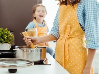 A woman and child cooking spaghetti