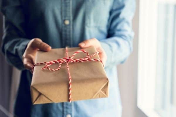 man holding gift to symbolize gift ideas for person who has everything