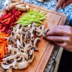 person chopping vegetables on cutting board for meal prep organization