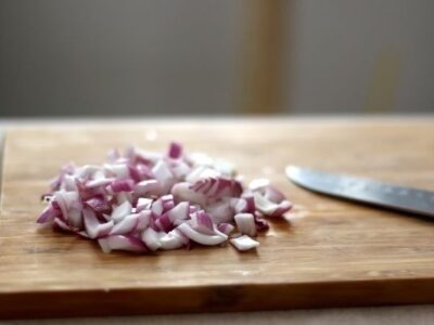 meal prep tips chopped up onion on cutting board with knife