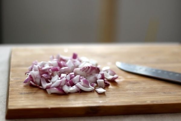 meal prep tips chopped up onion on cutting board with knife