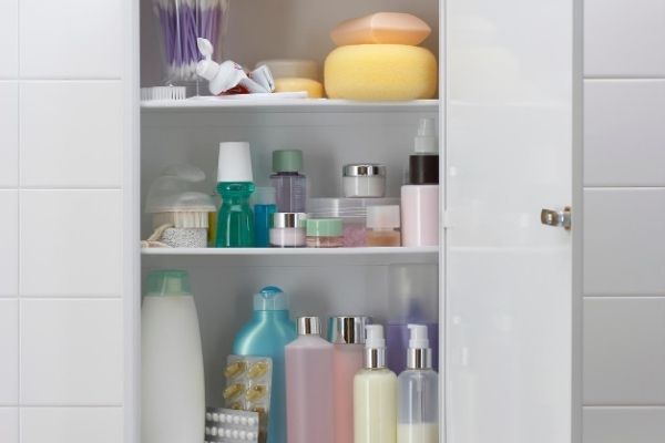 Organized medicine cabinet in bathroom, filled with bottles and containers