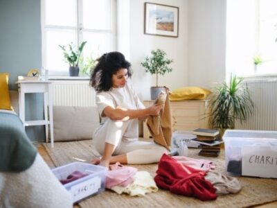 woman doing month of decluttering putting clothes in piles