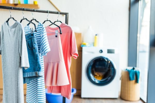 Laundry room with dryer, hanging clean clothes