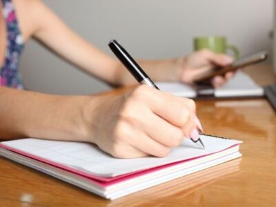 woman writing in spiral notebook to symbolize organize your ideas with notebooks concept