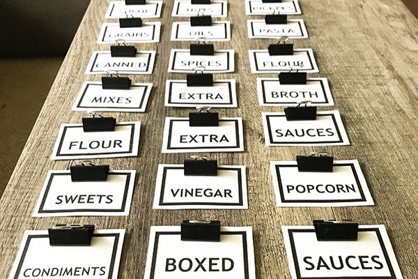A close up of pantry labels for pantry categories on a wooden table