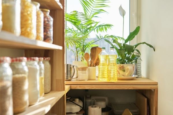 pantry organization shelf filled with jars of food in front of window