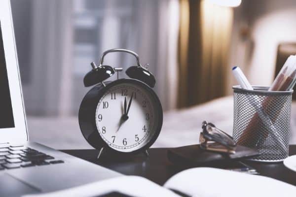 black clock on desk in office to represent a power hour