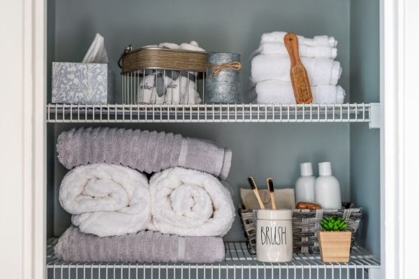 organized linen closet with gray white towels