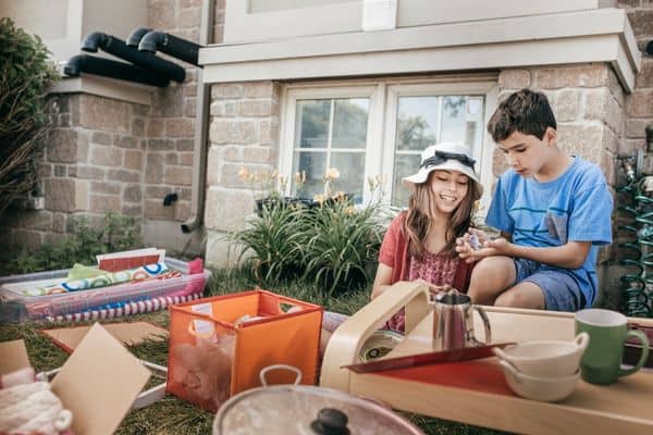 boy and girl looking at items at garage sale