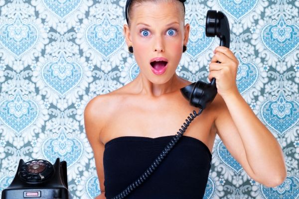 A woman answering telephone with surprised face