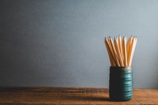 sharpened pencils in pottery mug on desk in organized office