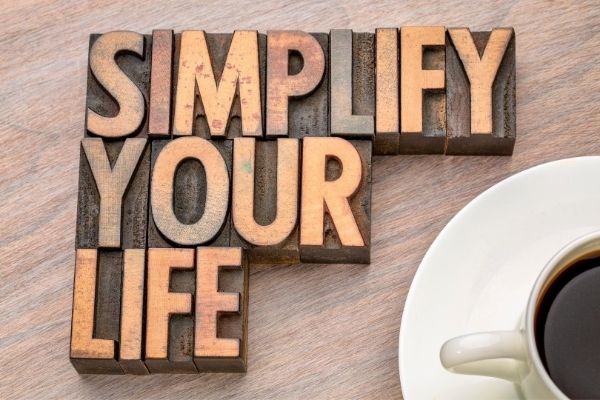 A wooden table with the words simplify your life spelled out in blocks