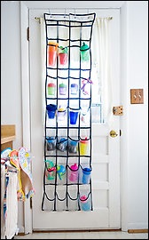 A close up of a door with shoe organizer holding different water bottles