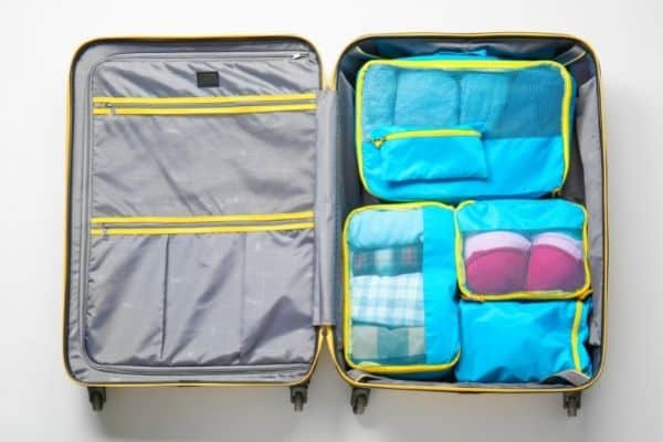 suitcase with packing cubes clothes rolled and organized