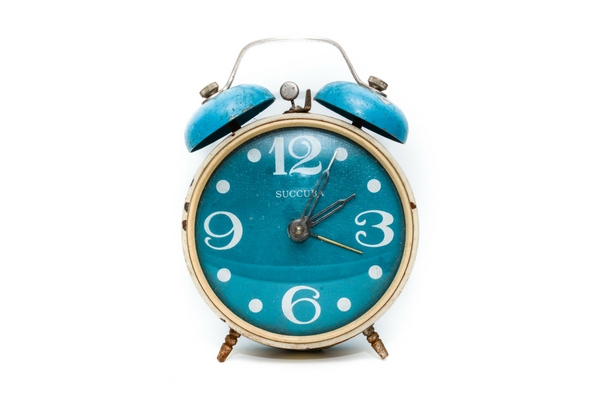 A close up of a turquoise clock used for time management